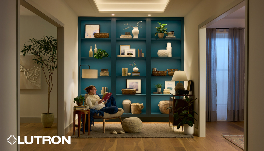 Cozy reading nook with modern lighting, a teal built-in bookshelf, and a person reading in a softly lit hallway.